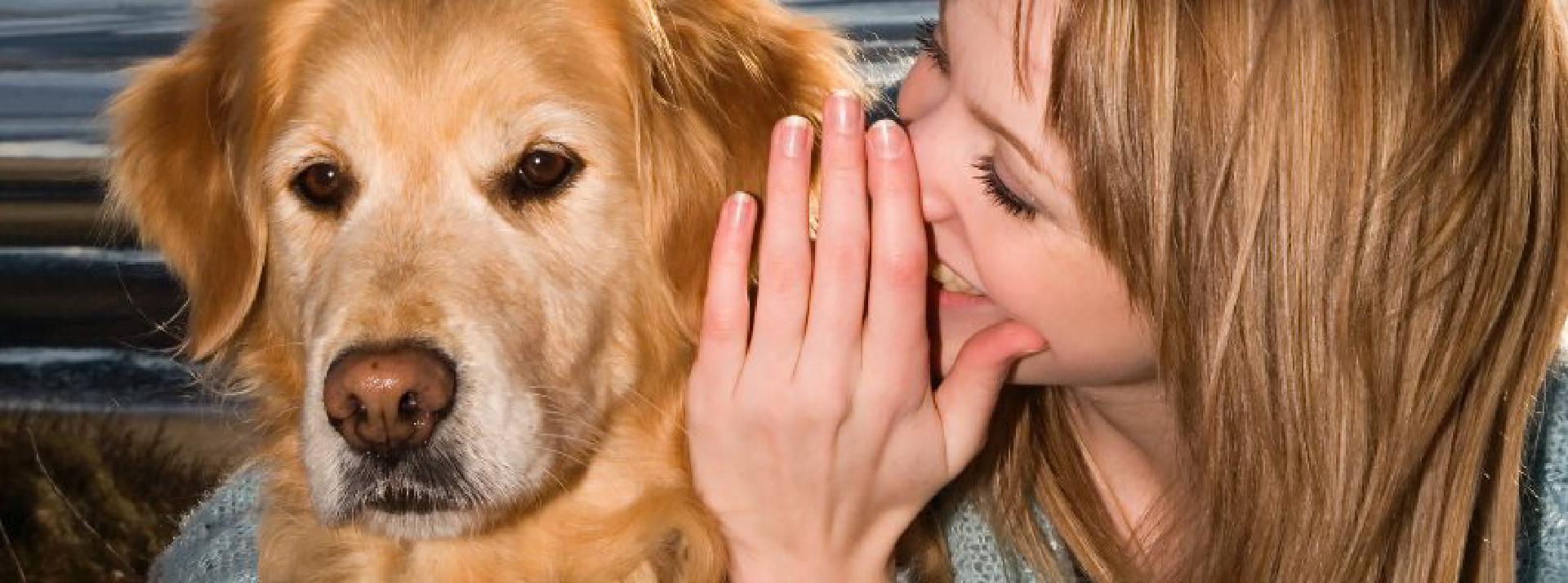 Young Woman Whispering into Dog's Ear